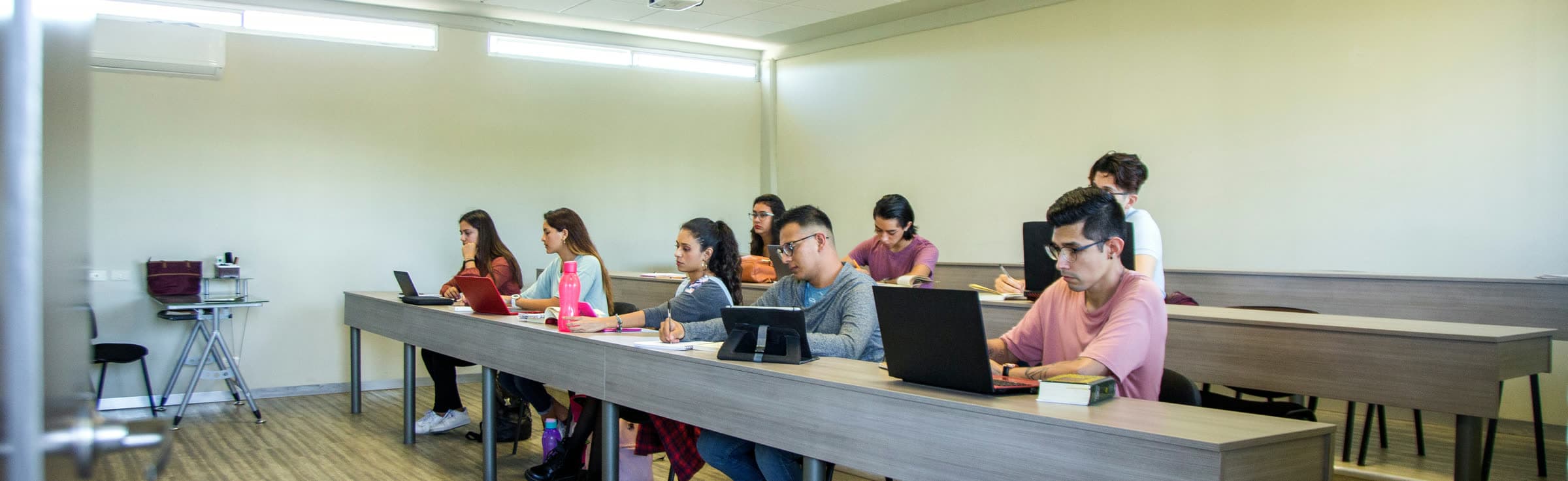 Students focused on laptops and notes during a study session in a classroom